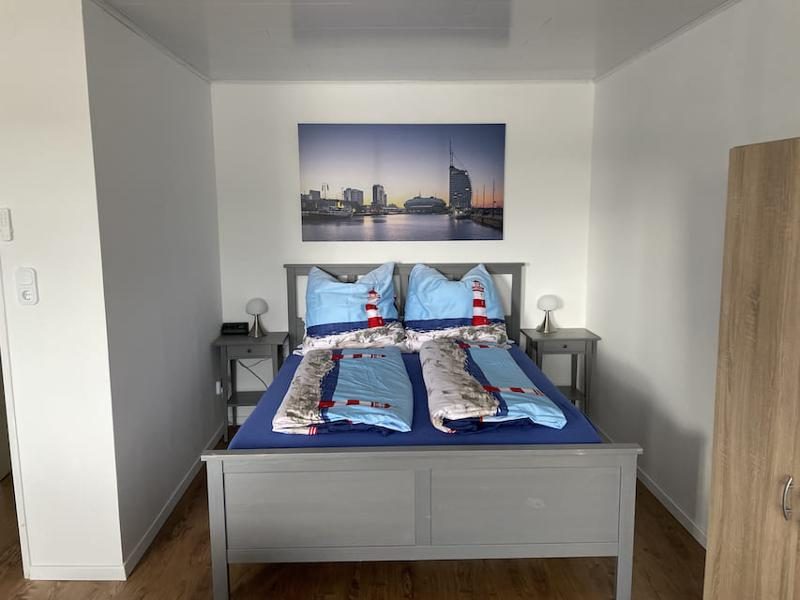 Schlafzimmer mit Doppelbett und maritimer Dekoration in der Ferienwohnung Luna Blu